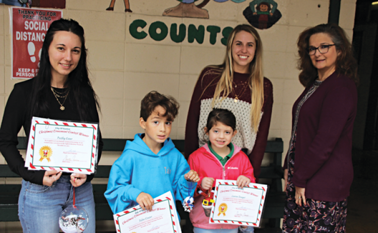 From left, are Heather Lanclos with the Mayor’s Office, Talan Ceasar, and Lauren Douget, Ornament Contest winners; Courtney Elkins with City of Eunice;  and Principal Laura Lombas. Not pictured is Paisley Cesar. (Photos by Myra Miller)