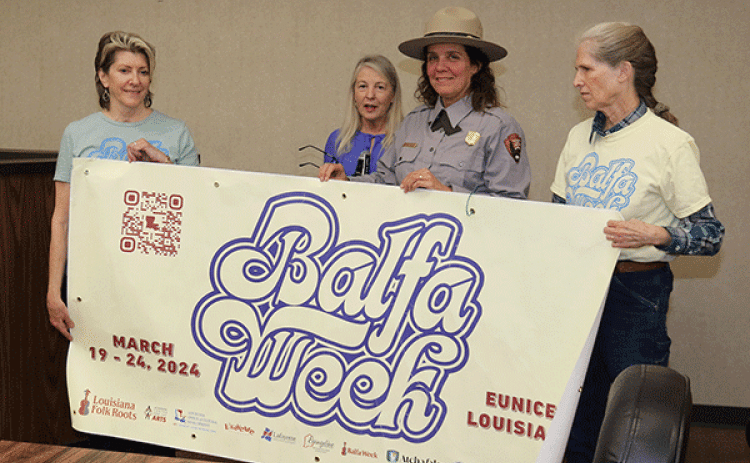 A banner for Balfa Week was shown at the Eunice Board of Aldermen’s meeting in December. From left, are Jean Johnson, Louisiana Folk Roots Board treasurer; Jeanne Solis, Folk Roots executive director; Angela Rathle, supervisory National Park Ranger; and Lorraine Shelton- Gaines, Folk Roots Board president. (Photo by Harlan Kirgan)