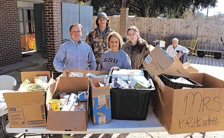 Donnie Richard, a Rotarian, delivered 456 pounds of food items from Highland Early Learning Center Tuesday at the Eunice Food Bank Food Drive. From left, are Richard, Owen Young, Pam Joubert, and Bailey Young.  (Photo by Myra Miller)
