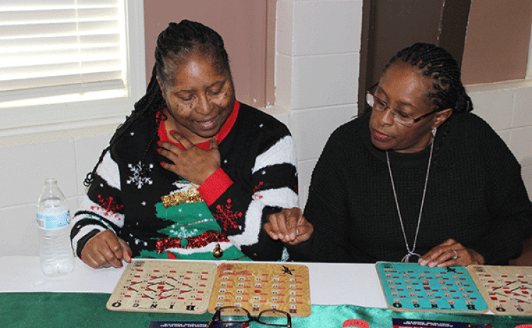 Daphney Victoria, left, and Sharlan Williams play bingo.