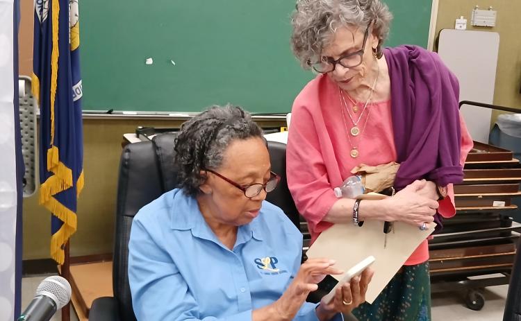 School board members Hazel Sias and Mary Ellen Donatto look over the budget before leaving a school board meeting. (Photo by Bobby Ardoin)