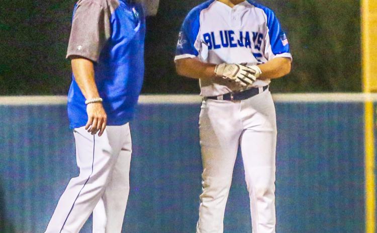 St. Edmund head coach Barry Manuel congratulates Clay Aguillard when he reached third base.