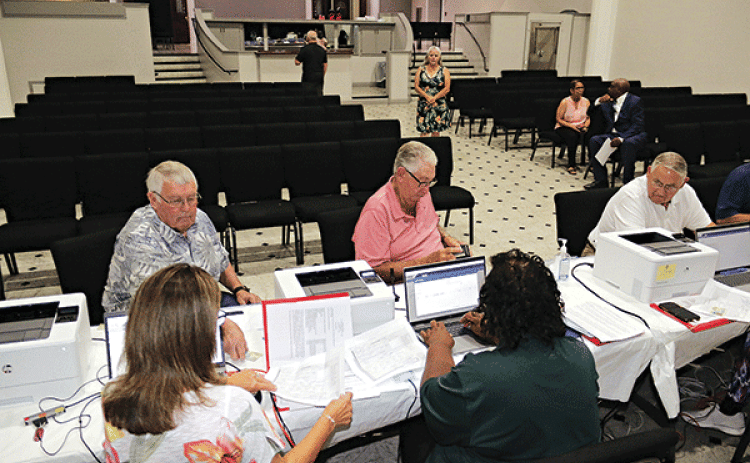Candidates for St. Landry Parish Council seats, from left, are Wayne Ardoin, District 9, Alvin Stelly, District 7, and Harold Taylor, District 5. They were the first to take seats to give their information to qualify for the October election. Qualifying is held at the Delta Grand Theater in Opelousas and ends at 4:30 p.m. Thursday. (Photo by Harlan Kirgan)