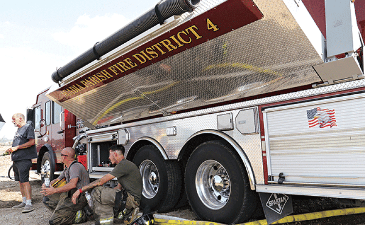 Firefighters take a break from the sun in the shade of an Acadia Parish Fire District 4 truck while battling a fire off La. 358 and Houston Richard Road on Aug. 24. The day  happened to be one of the hottest days of 2023 with a high of 106 degrees, according to the National Weather Service. From left, are Harral “New York” Johnson, Acadia Parish Fire District 4 chief; Chris Pierrotti, Eunice volunteer firefighter; and Dylan Fontenot, St. Landry Parish Fire District 6 volunteer. (Photos by Harlan Kirgan)