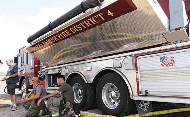 Firefighters take a break from the sun in the shade of an Acadia Parish Fire District 4 truck. From left, are Harral “New York” Johnson, Acadia Parish Fire District 4 chief; Chris Pierrotti, Eunice volunteer firefighter; and Dylan Fontenot, St. Landry Parish Fire District 6 volunteer.