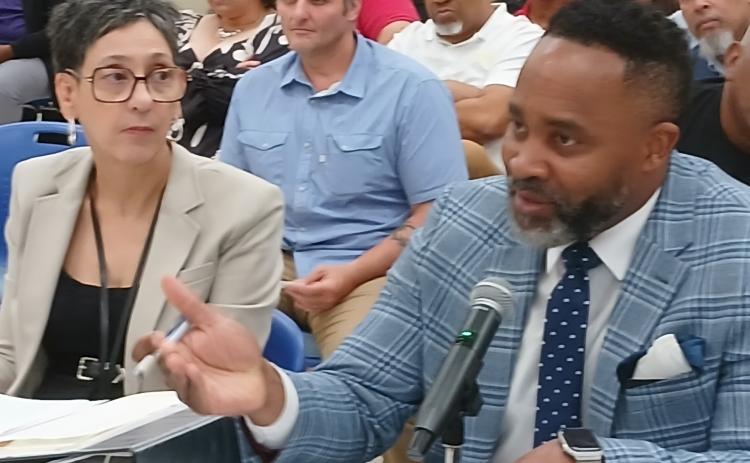 Board attorney Courtney Joiner, Superintendent's secretary Valencia Thierry looks at the presentation