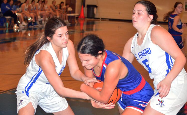St. Edmund’s Jillian DeVillier and Alice Brown battle South Cameron’s  Reagan Veronie for a jump ball. (Photo by Tom Dodge)