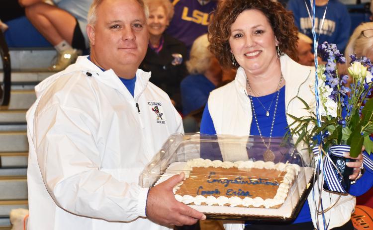 St. Edmund athletic director James Shiver presents head girls basketball coach Erica Zaunbrecher a cake, flowers and balloons after her 19th win – a season high record for the Lady Jays coach. 