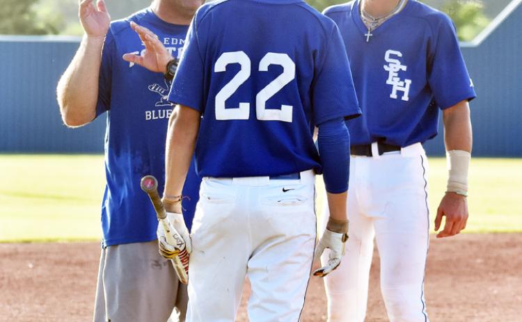 St. Edmud head coach Nick Trosclair talks with two Blue Jay players.