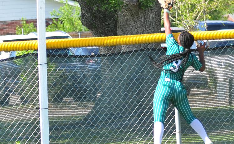 Eunice High right fielder Harmony Jason leaps as a North DeSoto home run clears the fence.