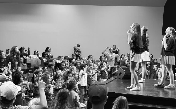 Kids singing facing the stage 