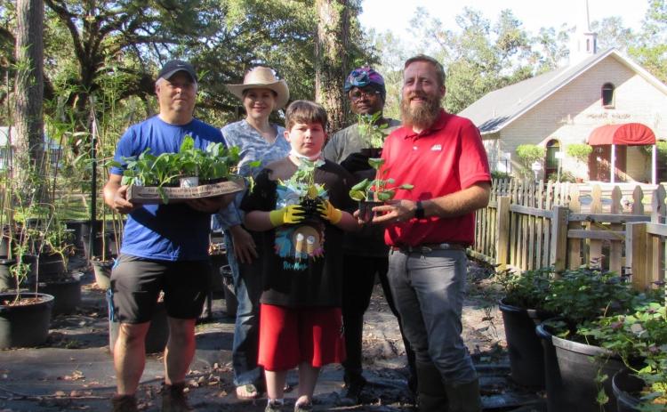 Gardeners holding produce. Covington Community Garden volunteers are preparing to rebuild what was damaged by Hurricane Ida. Pictured are Tim Ellzey, the volunteer garden manger, LSU AgCenter family and consumer sciences regional coordinator Valerie Vincent, Covington Kids Garden Club member Jaiden Gifford, Pam McKay of Gods Unchanging Hand Feeding Ministry and AgCenter agent William Afton. (Photo by Valerie Vincent/LSU AgCenter)