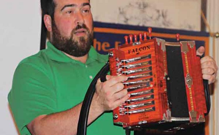 Rusty Sanner, of Milton, shows one of his accordions at the Eunice Rotary Club meeting on Wednesday. (Photo by Myra Miller)