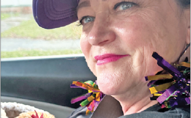Audrey Houston, pictured, and her friend Stacy Parker, both of Baton Rouge, left the 2025 Cajun Mardi Gras Festival with a feathered souvenir — Eunice the rooster.  Houston holds Eunice on the drive back to Baton Rouge. (Submitted photo)