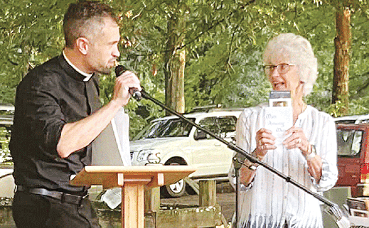Carrol LaFleur, right, talks about books on the life of the Rev. Verbis LaFleur, who was declared a servant of God by the Diocese of Lafayette. On the left is the Rev. Travis Abadie, pastor of St. Francis Regis Catholic Church of Arnaudville. (Photo courtesy of St. Bernard Catholic Church)