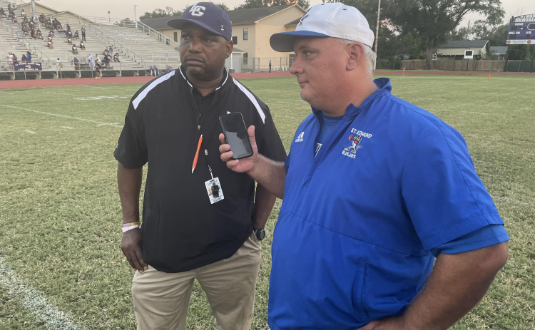 St. Edmund head coach James Shiver holds his phone as he and LaGrange head coach Maricco Wilson talk with a LHSOA official. (Photo courtesy of Barry Spears)