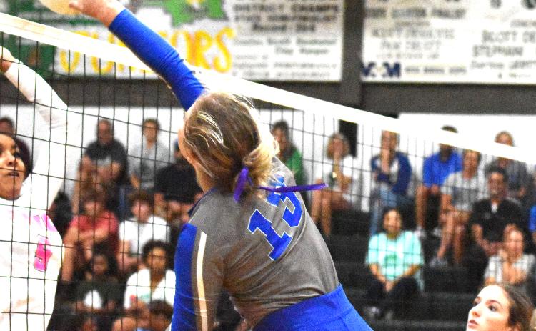 St. Edmund’s Ava Smith hits the ball as Eunice High’s Denina Ned defends on the play.